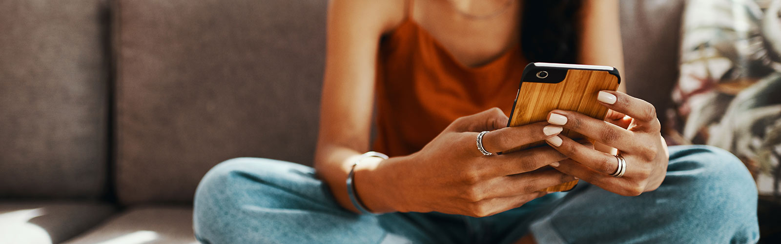 Woman using mobile phone on couch.