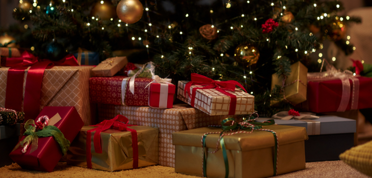 Christmas gifts stacked up beneath a Christmas tree